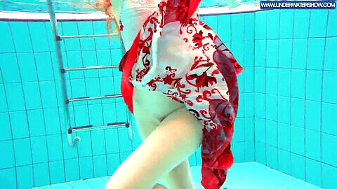 Fiery Polish redhead enjoying a steamy swim in the pool, showing off her curves in see-through bikini