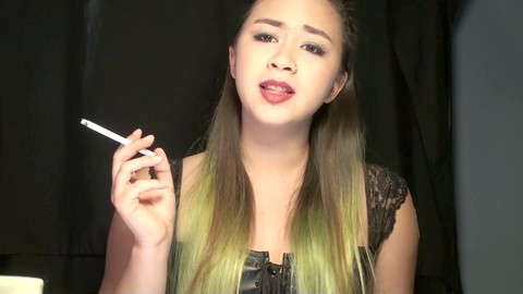 Alternative Asian smoker indulges in kink by wearing a 21mg Nicotine Patch and smoking two cigarettes while dominating her submissive collared slave.